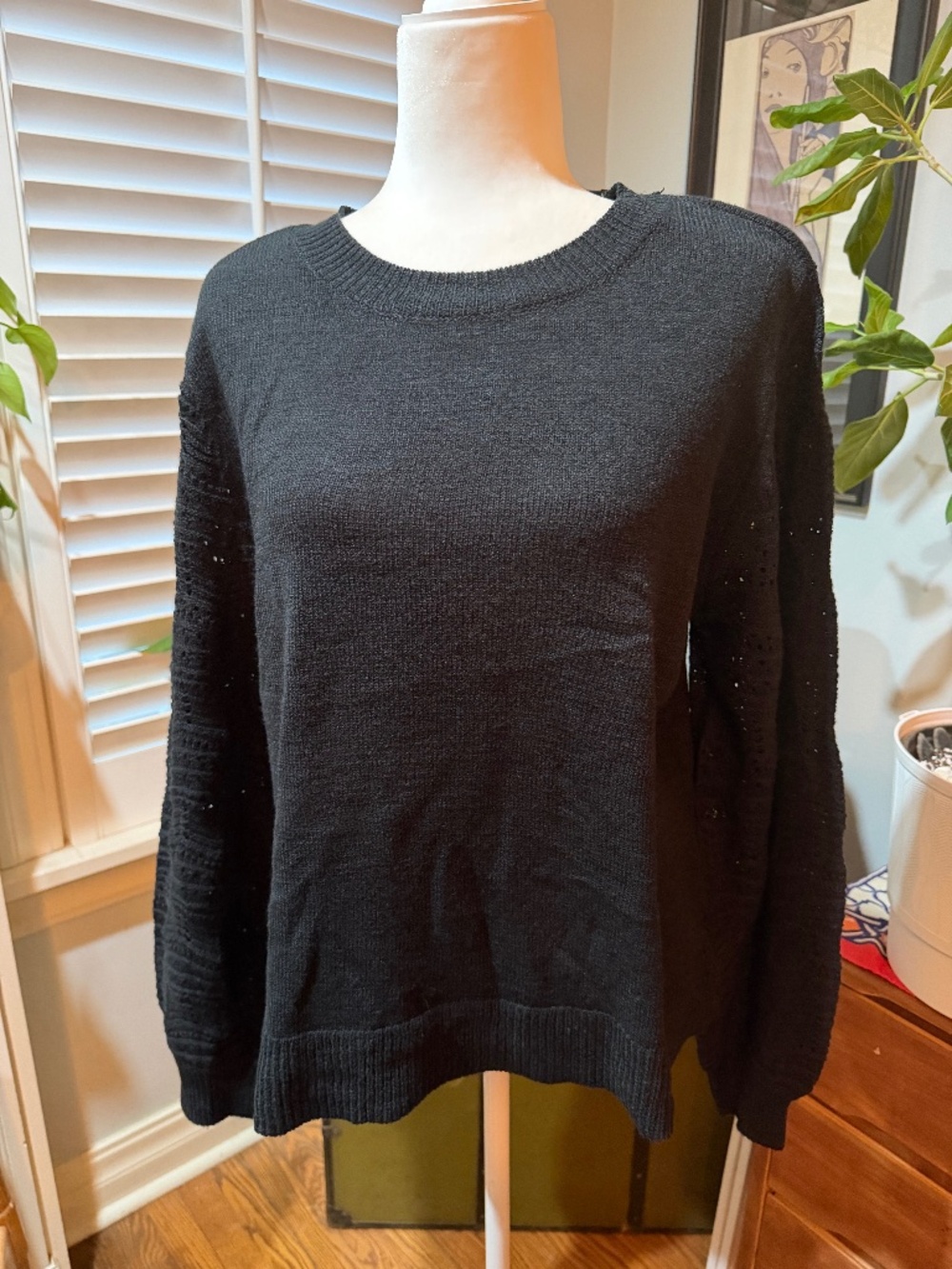 Lightweight black sweater with crocheted sleeve details.